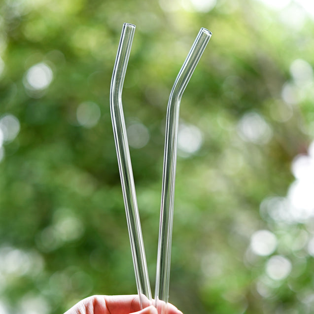 hands holding 2 straight glass straws during the day outdoors 8mm wide