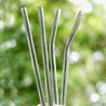 hands holding 2 straight glass straws and 2 bendy glass straws during the day outdoors 8mm wide